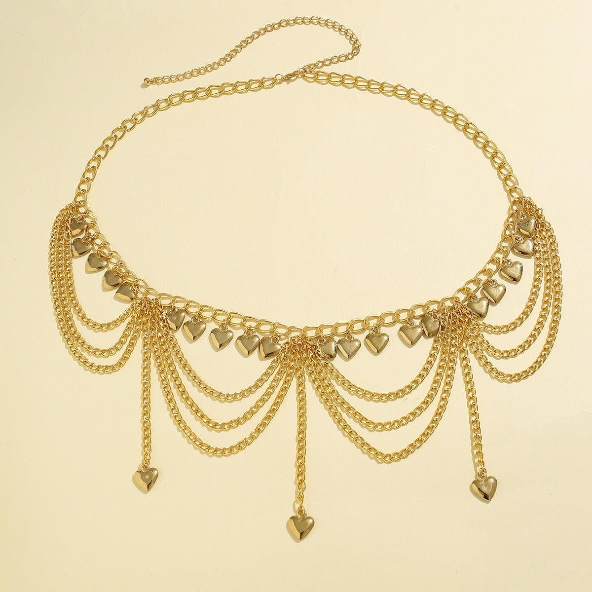 Close-up view of gold-plated waist chain with multi-layered tassel design and small bells