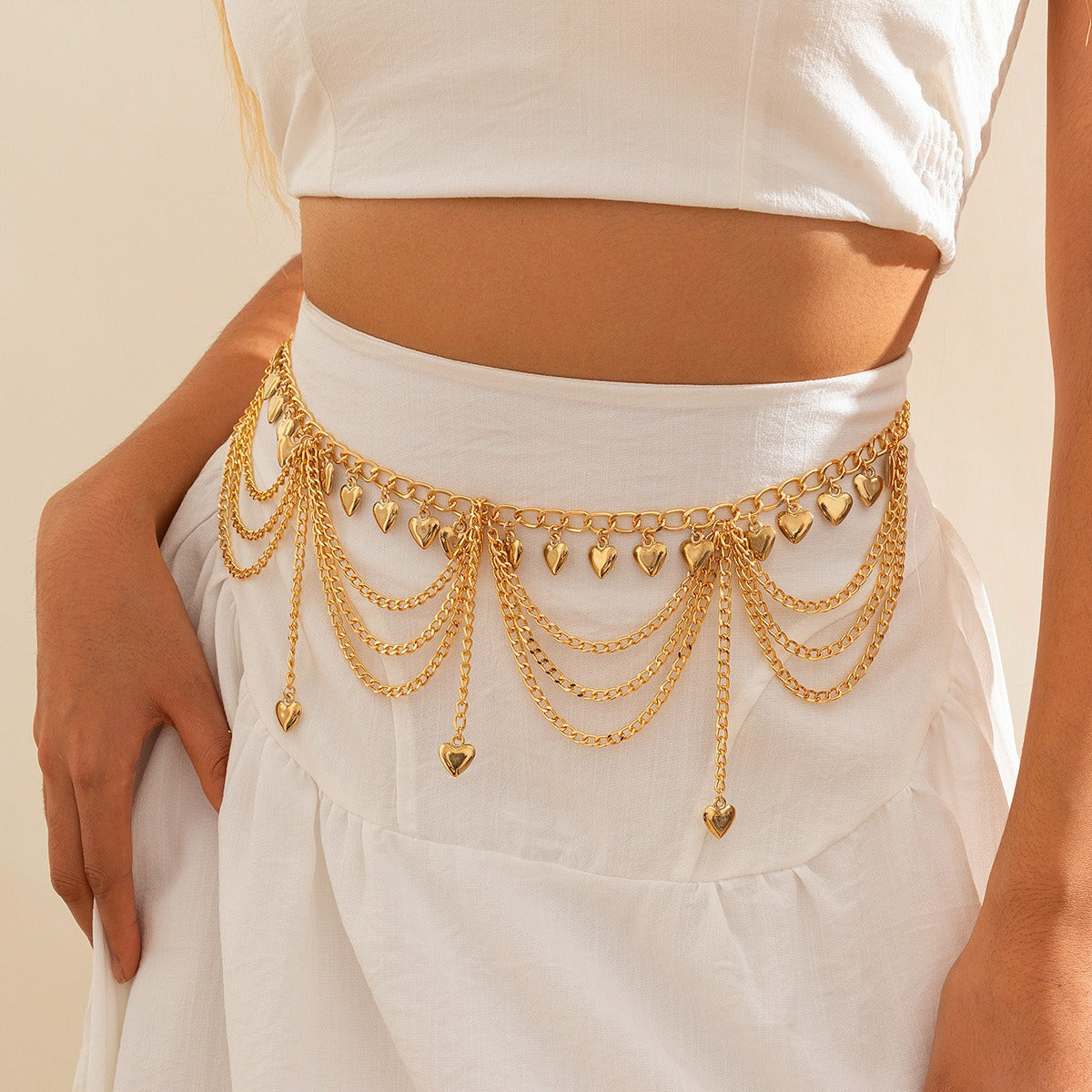 Side view of boho gold waist chain with multi-layered chains and dangling bells, worn with white outfit