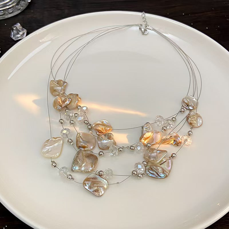 Close-up detail of pearl shell layered necklace with crystal beads