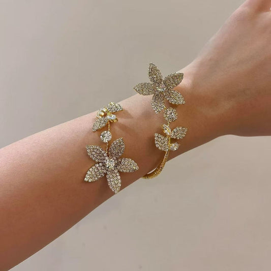 Elegant gold crystal flower bangle for women, detailed close-up of sparkling petals, adjustable open bracelet, luxury fashion accessory